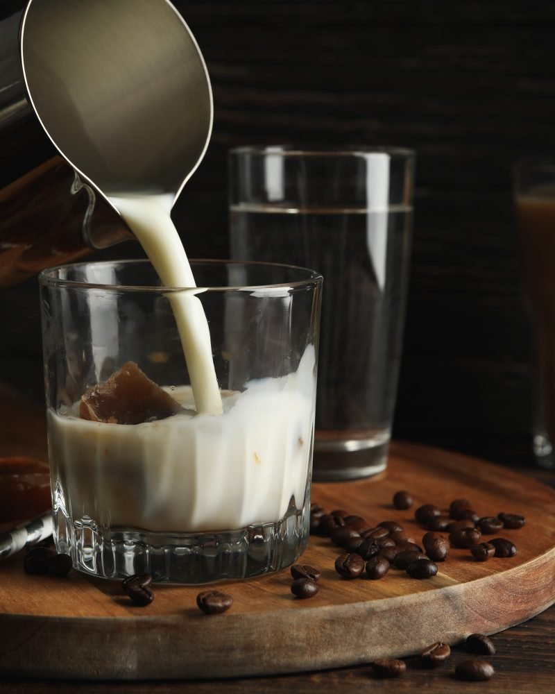 milk-is-poured-into-a-glass-of-coffee-composition-with-ice-coffee.jpg